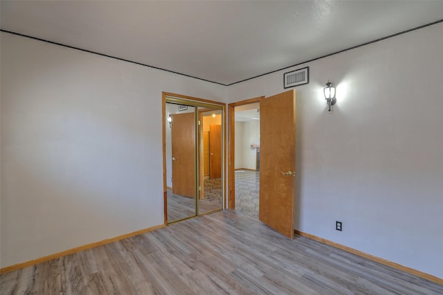 unfurnished room featuring visible vents, baseboards, and light wood-style floors