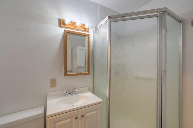 bathroom featuring toilet, vanity, and a shower stall