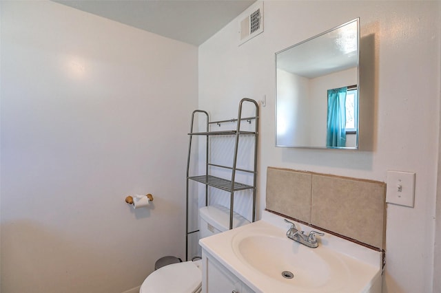 bathroom featuring toilet, visible vents, and vanity