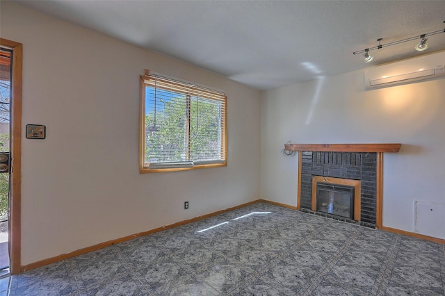 unfurnished living room featuring a brick fireplace, a wall mounted AC, and baseboards