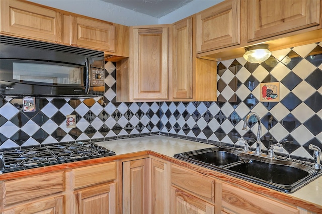 kitchen with black appliances, decorative backsplash, and a sink