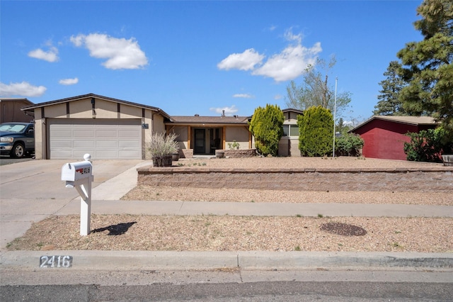 2416 Avenida De Las Campanas, Santa Fe, NM 87507 - view of front of house with driveway, an attached garage, and stucco siding