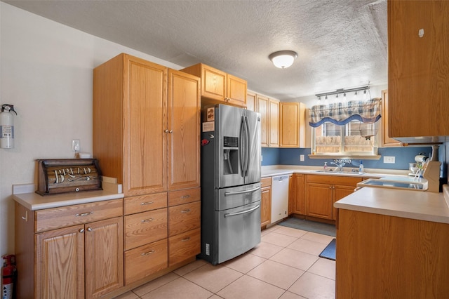 2416 Avenida De Las Campanas, Santa Fe, NM 87507 - kitchen featuring stainless steel refrigerator with ice dispenser, dishwasher, light countertops, a sink, and a textured ceiling