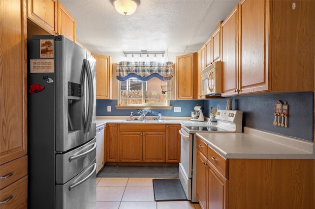 2416 Avenida De Las Campanas, Santa Fe, NM 87507 - kitchen with white appliances, a sink, a textured ceiling, light tile patterned flooring, and light countertops