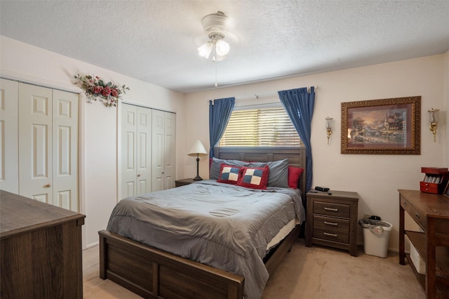 2416 Avenida De Las Campanas, Santa Fe, NM 87507 - bedroom with light carpet, multiple closets, and a textured ceiling
