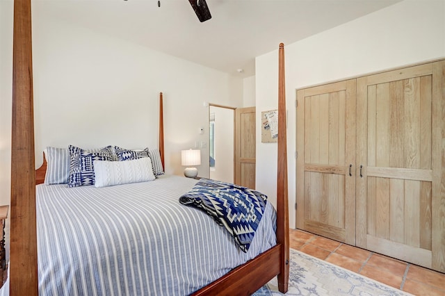 tiled bedroom with a ceiling fan and a closet