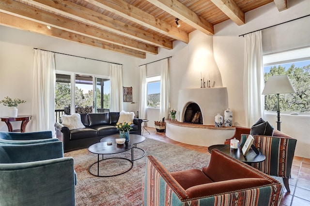 tiled living room featuring beamed ceiling, a large fireplace, and wood ceiling