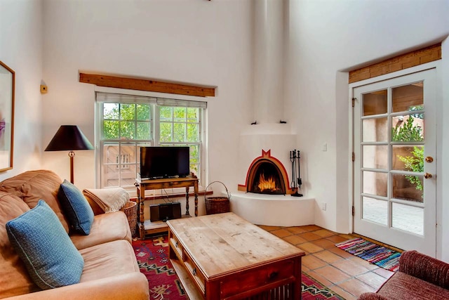 living room featuring a high ceiling, tile patterned flooring, and a fireplace
