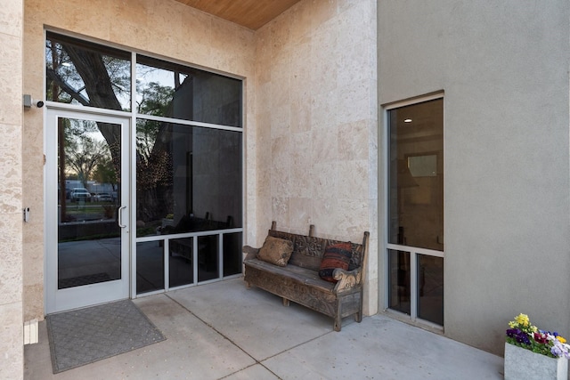 property entrance featuring stucco siding and a patio