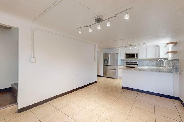 kitchen with white cabinetry, open shelves, stainless steel appliances, rail lighting, and a peninsula