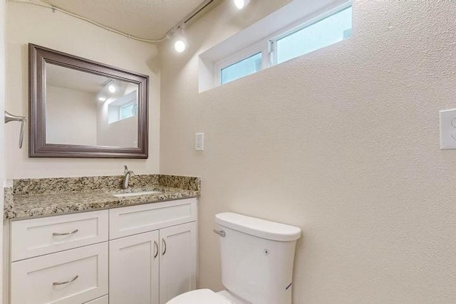 half bathroom featuring toilet and vanity