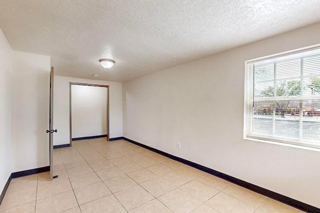 empty room with baseboards and a textured ceiling