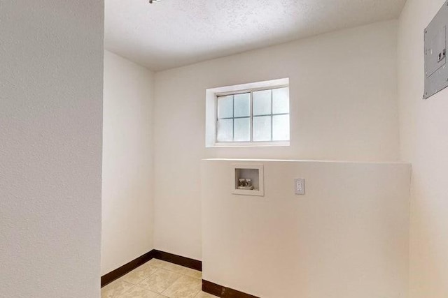 washroom featuring hookup for a washing machine, light tile patterned flooring, laundry area, and baseboards