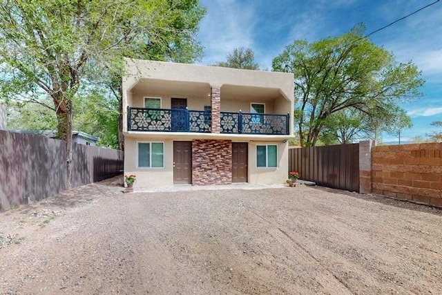 back of property featuring stucco siding, a fenced backyard, and a balcony