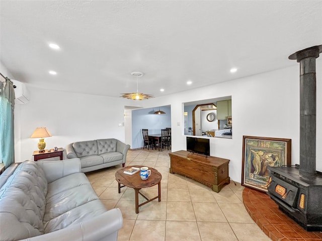 living area featuring ceiling fan, a wood stove, an AC wall unit, recessed lighting, and light tile patterned floors