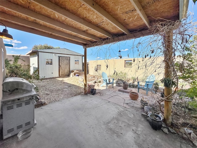 view of patio / terrace with area for grilling, a fire pit, an outbuilding, and a storage shed