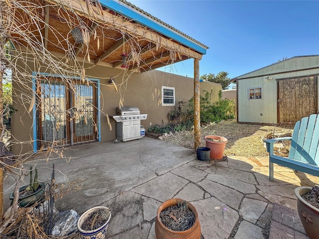 view of patio featuring area for grilling and an outbuilding