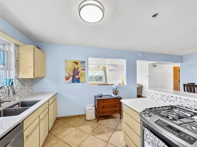 kitchen featuring a sink, light countertops, cream cabinets, and stainless steel appliances