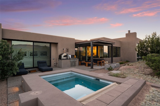 back of house featuring exterior kitchen, a chimney, a patio, and stucco siding