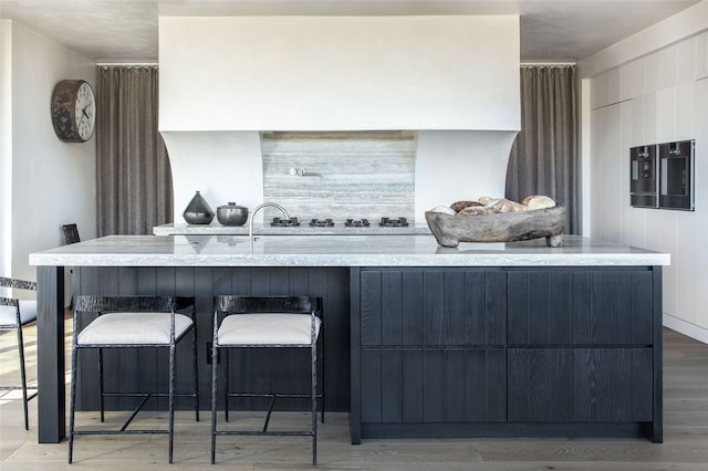 kitchen with light wood-style flooring, a breakfast bar area, modern cabinets, and a spacious island