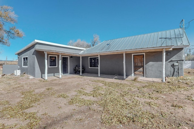 54 County Road B40A, Ribera, NM 87560 - back of house with stucco siding, metal roof, a patio area, and central air condition unit
