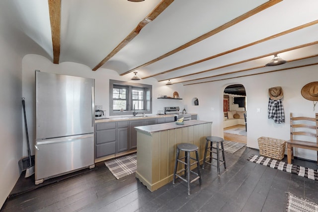 54 County Road B40A, Ribera, NM 87560 - kitchen featuring stainless steel appliances, arched walkways, gray cabinetry, light countertops, and a center island