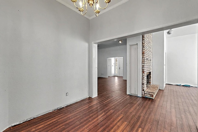 8228 Fairmont Dr NW, Albuquerque, NM 87120 - unfurnished room with ornamental molding, a brick fireplace, wood finished floors, and a notable chandelier