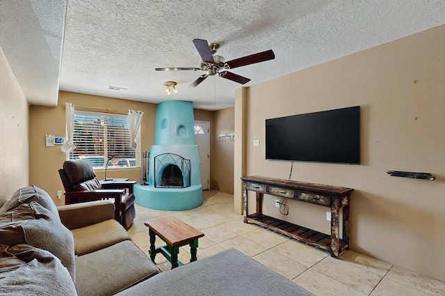 living area featuring light tile patterned floors, a ceiling fan, a textured ceiling, and visible vents
