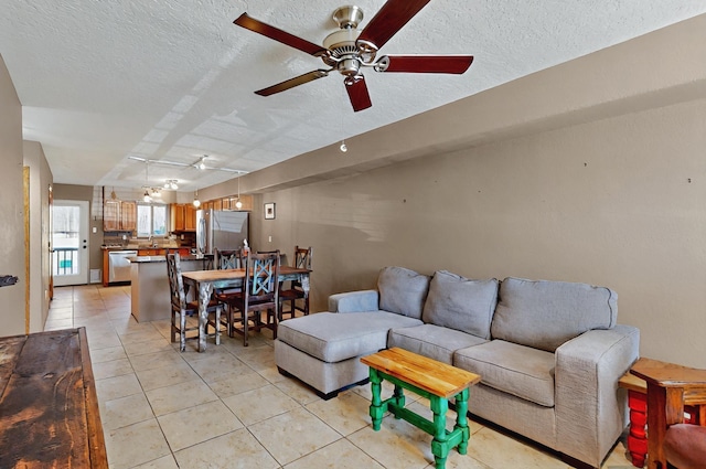living room featuring a textured ceiling, ceiling fan, and light tile patterned floors