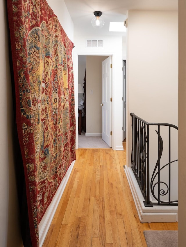 511 Armijo Unit C, Santa Fe, NM 87501 - hallway featuring visible vents, light wood-style floors, baseboards, and an upstairs landing