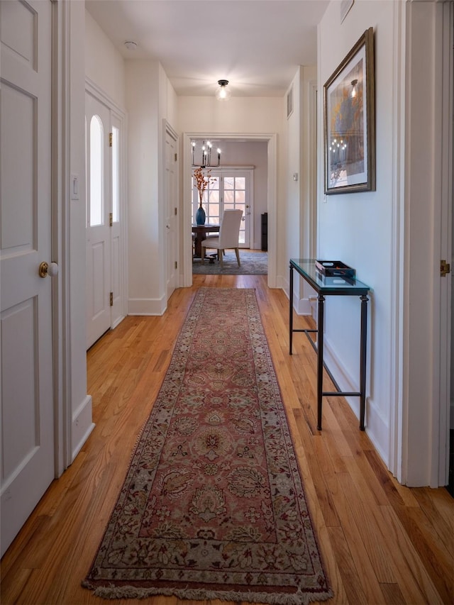 511 Armijo Unit C, Santa Fe, NM 87501 - corridor featuring baseboards, an inviting chandelier, visible vents, and light wood-type flooring