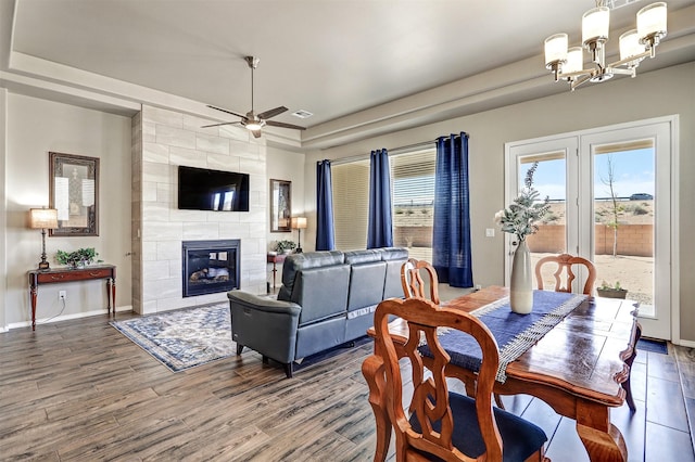 6841 Cleary Loop NE, Rio Rancho, NM 87144 - dining room with a ceiling fan, a tiled fireplace, wood finished floors, and a chandelier
