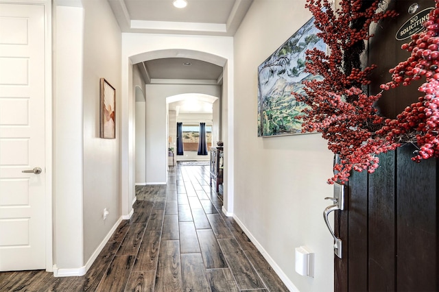 hall featuring baseboards, arched walkways, dark wood-style floors, and recessed lighting