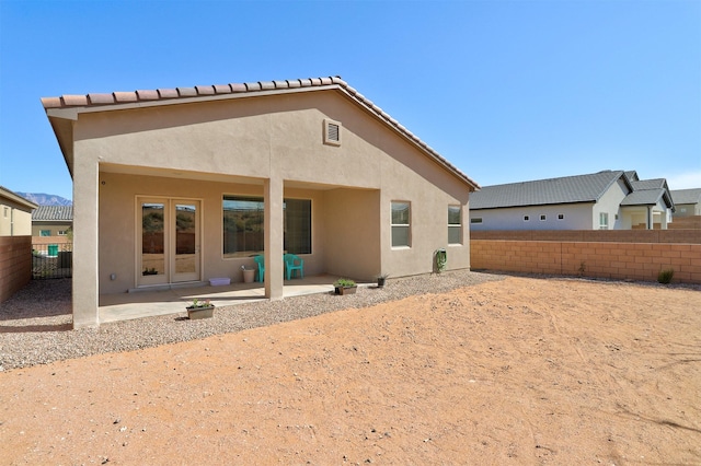 back of house with a fenced backyard, a patio, and stucco siding