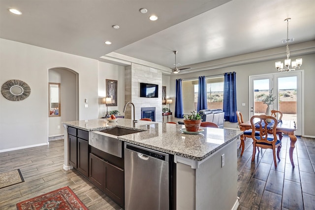 kitchen with open floor plan, an island with sink, a sink, dark wood finished floors, and dishwasher