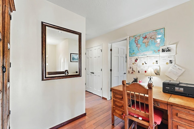 office space featuring baseboards and light wood-style floors
