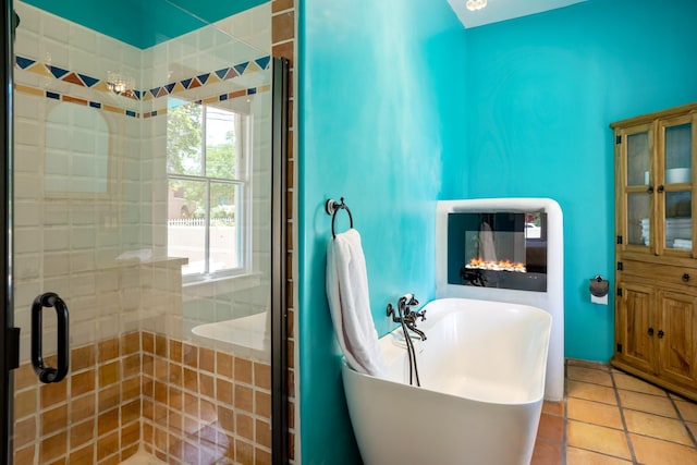 bathroom featuring tile patterned floors, a soaking tub, and a stall shower