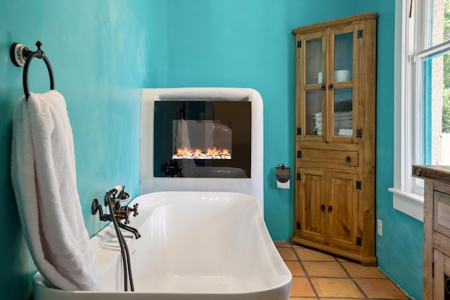 full bath featuring a freestanding bath, vanity, and tile patterned floors