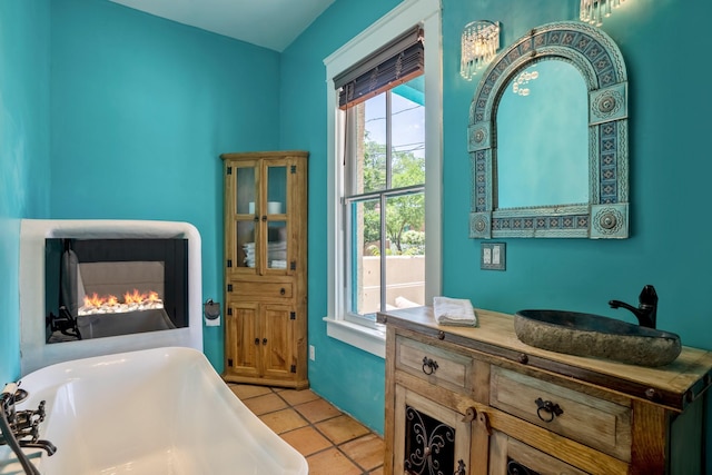 interior space with a freestanding bath, a wealth of natural light, tile patterned flooring, and vanity