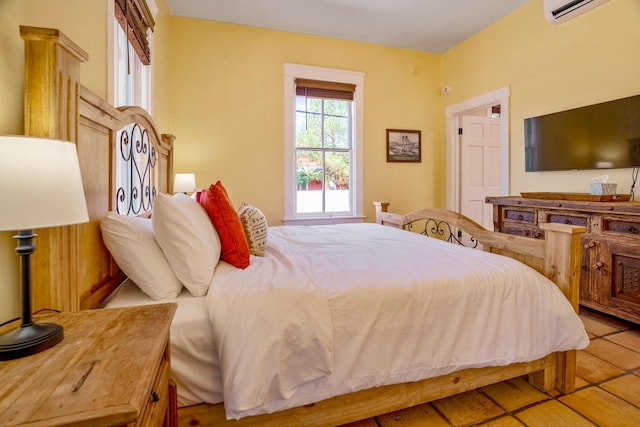 bedroom with tile patterned floors and an AC wall unit