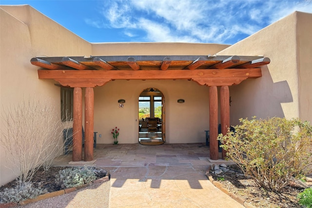 property entrance with a pergola