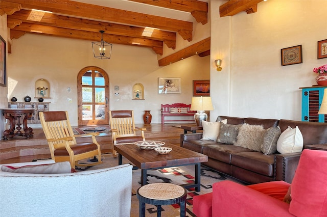 living room with arched walkways, a towering ceiling, and beamed ceiling
