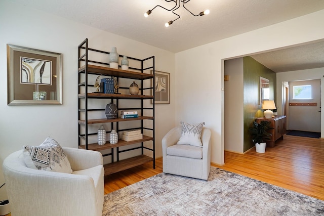 sitting room featuring a notable chandelier and wood finished floors