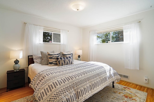 bedroom with wood finished floors and visible vents