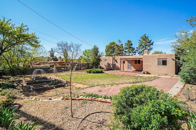view of yard featuring a fenced backyard, a patio area, and a vegetable garden