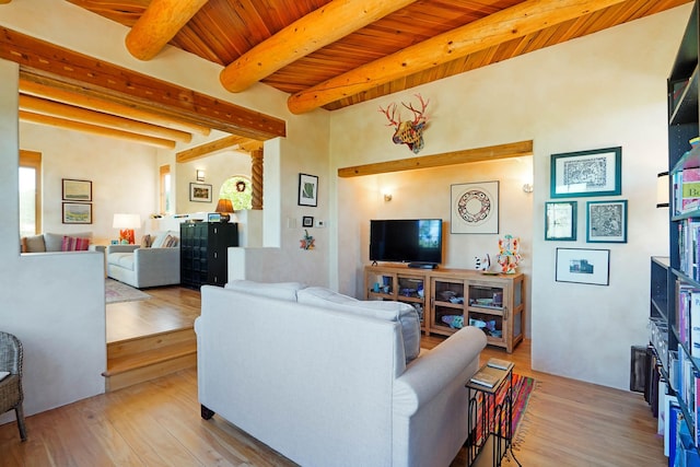 living area featuring beamed ceiling, wooden ceiling, and light wood-style floors