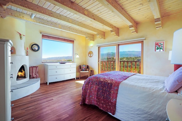 bedroom with wood ceiling, wood finished floors, beam ceiling, and access to exterior