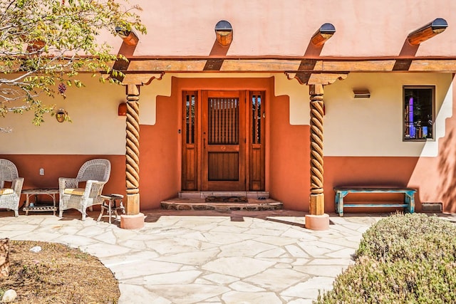 doorway to property featuring stucco siding