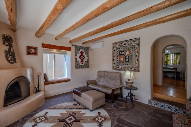 living room with arched walkways, a wall mounted AC, a healthy amount of sunlight, and beam ceiling