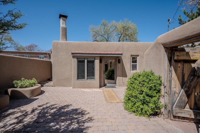 246 Maynard St, Santa Fe, NM 87501 - rear view of property featuring stucco siding, fence, and a patio